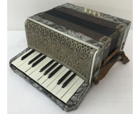 A vintage German Ceka Superior accordion with pearlised veneer and leather strap.