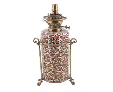 AN ENGLISH POTTERY AND BRASS MOUNTED CYLINDRICAL OIL LAMP, the body with burnt orange, black and gilt foliate decoration, ada
