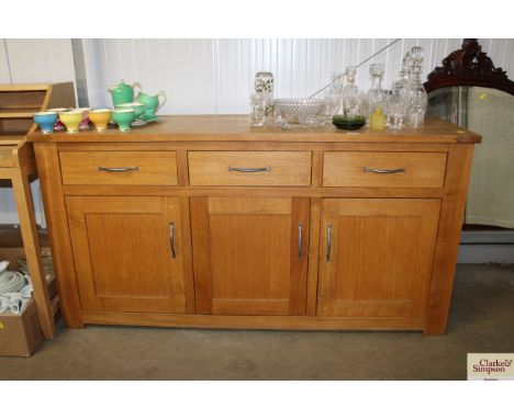 A modern light oak sideboard fitted three drawers