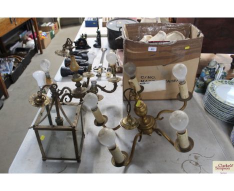 A lantern style light fitting and two five branch ceiling lights and a box of shades