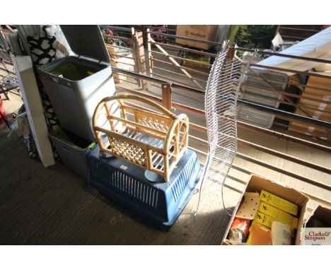 A plastic pet carrier, cane magazine rack and a metal CD rack