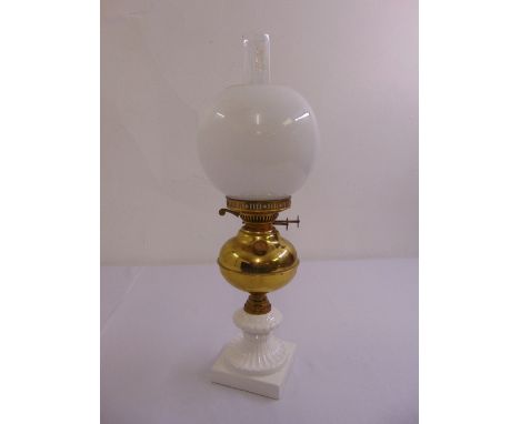 A Victorian style glass and brass oil lamp with globular shade and square base
