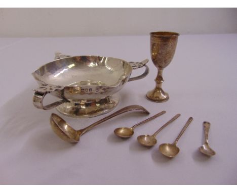A silver hand hammered bowl with scroll handles on raised circular base, London 1904, a silver sauce ladle, four condiment sp