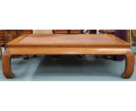 A 20th century Oriental hardwood framed daybed/coffee table with rattan insert top on shaped supports, 45cm high x 159cm long