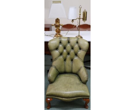 A contemporary green button back leather upholstered lounge chair, gilt figural table lamp in the form of a lion and another 