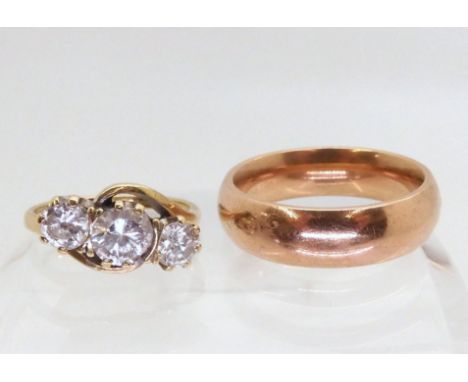 A gents 9ct rose gold court wedding band size T, together with a 9ct clear gem three stone ring size M1/2 (af), weight combin