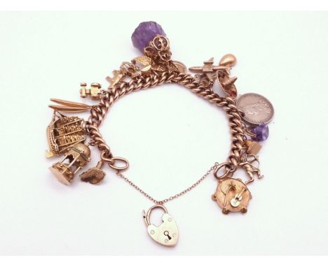 A 9ct gold charm bracelet with Two 18k charms, thirteen 9ct charms, five yellow metal charms and a silver Victorian coin. T o