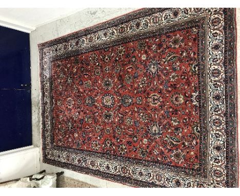 A Persian carpet, the central panel set with all over floral and foliate decoration on a red ground within a stepped red, blu