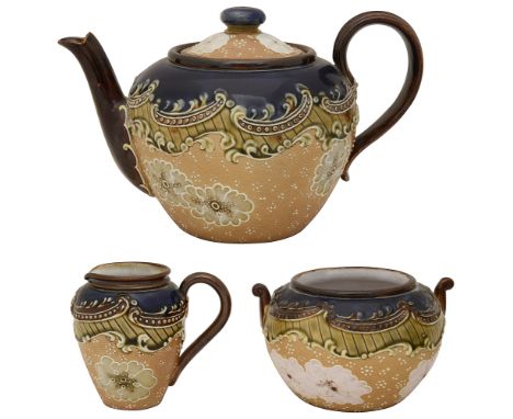 A Doulton Lambeth Slaters Patent stoneware three piece tea servicedecorated with textured lace ground with flowerheads and co