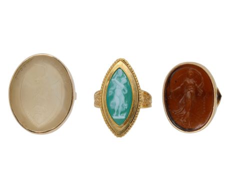 Three glyptic and yellow gold ringsthe first collet-set with an oval white hardstone intaglio-engraved  with a shield, crest 