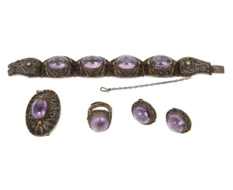 A Chinese silver filigree and cabochon amethyst demi parure of jewellery c.1930.comprising a hinged panel bracelet with push 