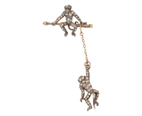 An early 20th century colourless paste-set double monkey broochdesigned as one monkey sitting on a yellow gold bar with seed 