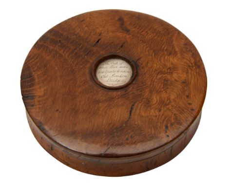 An early 19th century turned oak snuff box of circular form the pull cover bearing central white metal button engraved ' 'The