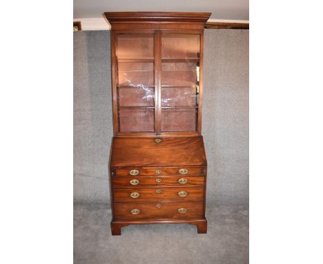 A Georgian mahogany bureau bookcase, the upper glazed section above fall front revealing well fitted interior above four long