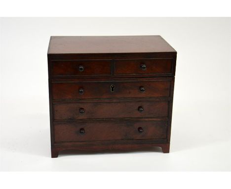 A miniature chest of drawers tea caddy, veneered in mahogany with ebony beading and turned handles. Circa 1810. 15cm x 16.5cm