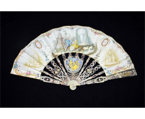 λ An 18th century ivory fan, with elaborately carved, pierced and gilded guards and sticks. The sticks with figures gilt in t