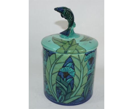 A Dennis Chinaworks jar and cover, After William De Morgan, decorated with underwater foliage and with a fish finial. Printed