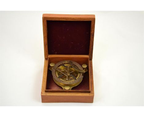 A brass compass in a wooden box.