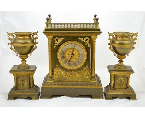 A brass and ormolu three piece clock garniture with corinthian pillars, the face with gilt brass and Roman numerals. Height 3