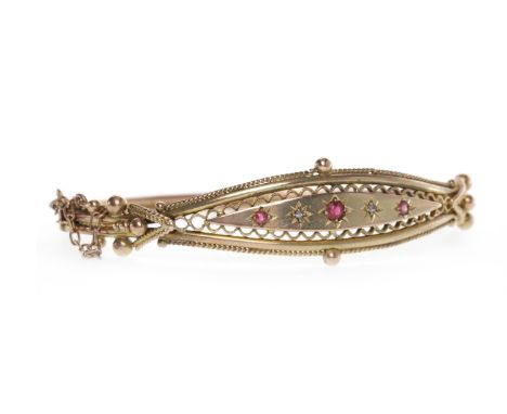 VICTORIAN NINE CARAT GOLD CREATED RUBY BANGLEwith a central solid elliptical section with three graduated cushion shaped crea