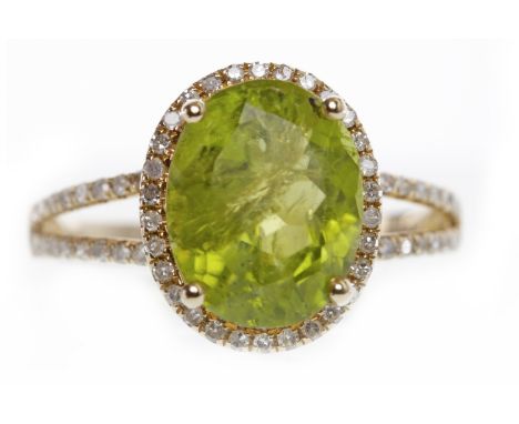 FOURTEEN CARAT GOLD PERIDOT AND DIAMOND RINGset with a central oval peridot of approximately 3.59 carats and within a diamond