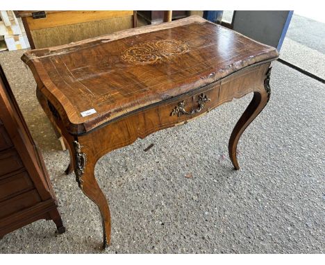 Continental walnut and inlaid card table with serpentine top and applied metal mounts, requiring extensive restoration