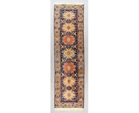 An Antique Lenkoran Runner, woven in colours, with seven bold quadruple hooked motifs interspersed by geometric and floral or