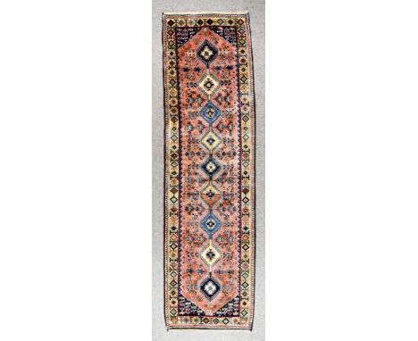 An Early 20th Century Yalameh Runner, woven in pastel shades, with nine hooked lozenge shaped medallions, the field filled wi