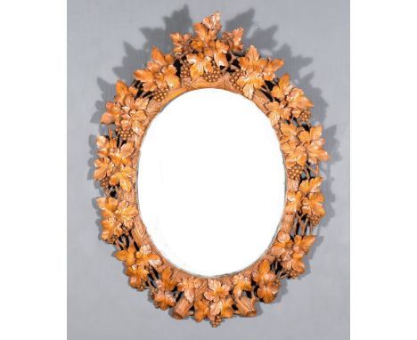 A Black Forest Carved Wood Oval Wall Mirror, 19th Century, the frame carved with fruiting vines, and inset with bevelled mirr