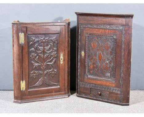 Two 18th Century Oak Corner Cupboards, each with moulded cornices and fitted shelves, enclosed by single carved panel doors, 