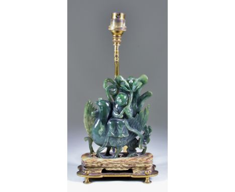 A Chinese Green Stone Carving of a Figure Seated on an Exotic Bird, on a composition base, with gilt metal electric light mou