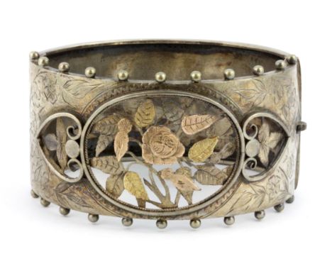 A hallmarked silver bangle with yellow and rose gold ornament, L. 6.5cm.