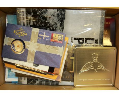 A box of First Day cover stamps with coins.