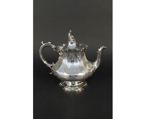 A Victorian silver teapot with ornate floral engraving on flared pedestal base with unusual finial in the form of a seated Ja