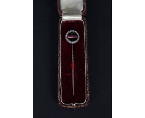 A lovely yellow and white metal stick pin set with ruby set and diamond circular border