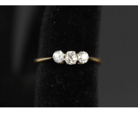 An 18ct gold three stone diamond ring (marks rubbed) size M
