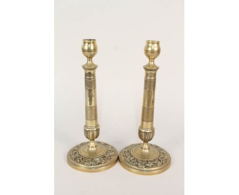 A pair of early 19th Century French seamed brass candlesticks with raised and engine milled decoration, 10 1/2" high