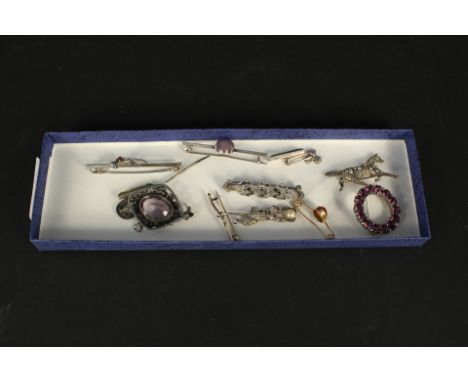 An interesting selection of silver jewellery including a brooch in the form of a monkey swinging from a branch holding a pear