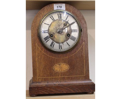 An Edwardian inlaid oak striking mantel clock