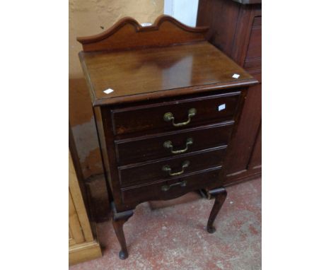 A 20" Edwardian mahogany music chest with shaped raised back and four fall-front drawers, set on cabriole front legs with pad