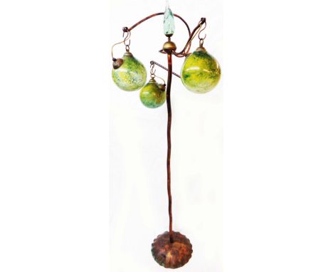 An Art Nouveau style coppered organic form standard lamp with central finial and three hand blown coloured glass sphere shade