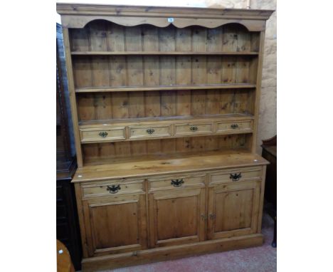 A 5' modern waxed pine two part dresser with moulded cornice and four spice drawers to three shelf open plate rack, over a ba