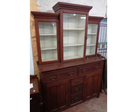 A 4' 5 1/2" Edwardian stained pine two part kitchen dresser with triple glazed break-front and stepped top section, over a ba
