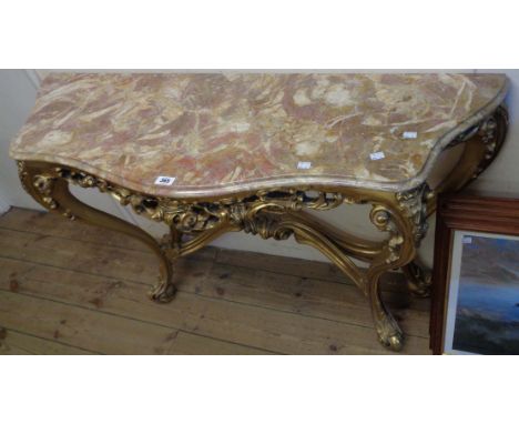 A 4' reproduction giltwood console table of serpentine form with moulded marble top and decorative pierced apron, set on cabr