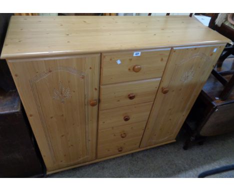 A 48 1/2" modern pine effect child's wardrobe/storage unit with five central drawers, hanging space and shelves enclosed by f