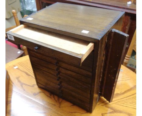 A 15" vintage stained mixed wood dental chest with flight of twelve drawers and locking bracket to side