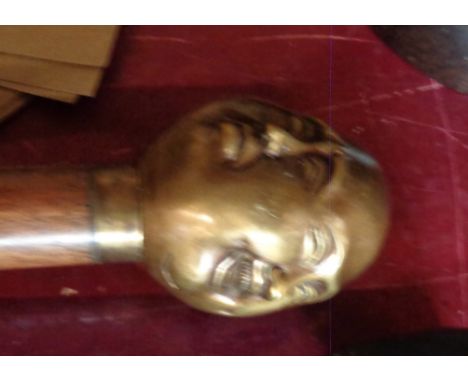A modern walking stick with a brass four sided head finial