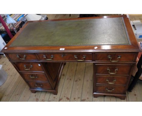 A 4' reproduction mahogany twin pedestal desk with green leather inset top, central frieze drawer and flanking pedestal drawe