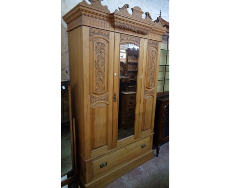 A 3' 10" Edwardian satin walnut wardrobe with ornate cornice, flanking decorative panels, hanging space enclosed by a mirror 