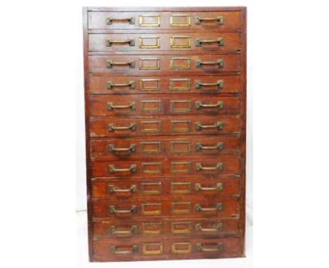 A 28" early 20th Century commercial oak filing chest with flight of twelve fall-front drawers and original fittings bearing G